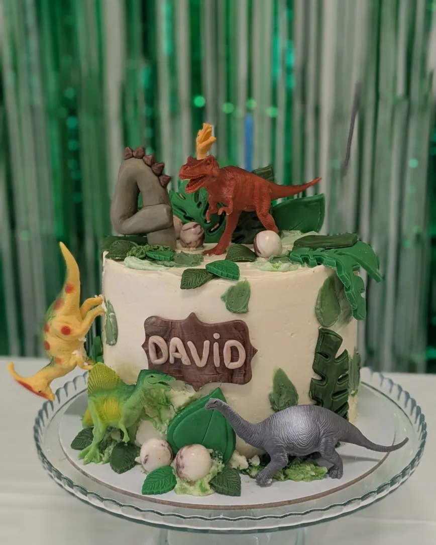 Themed birthday cake displayed on a glass cake stand.
