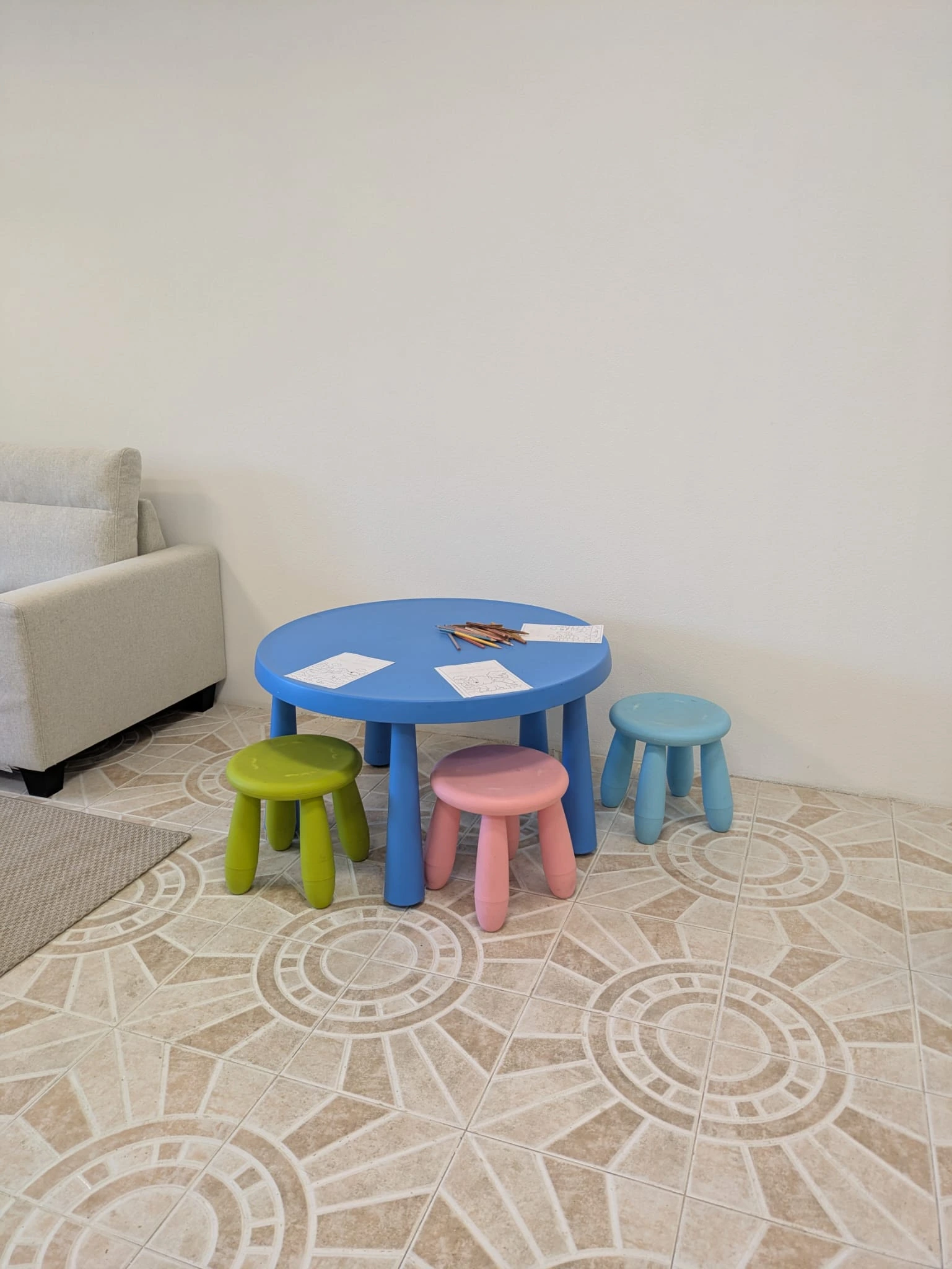 Kids' corner with colorful tables, small stools, and a slide.