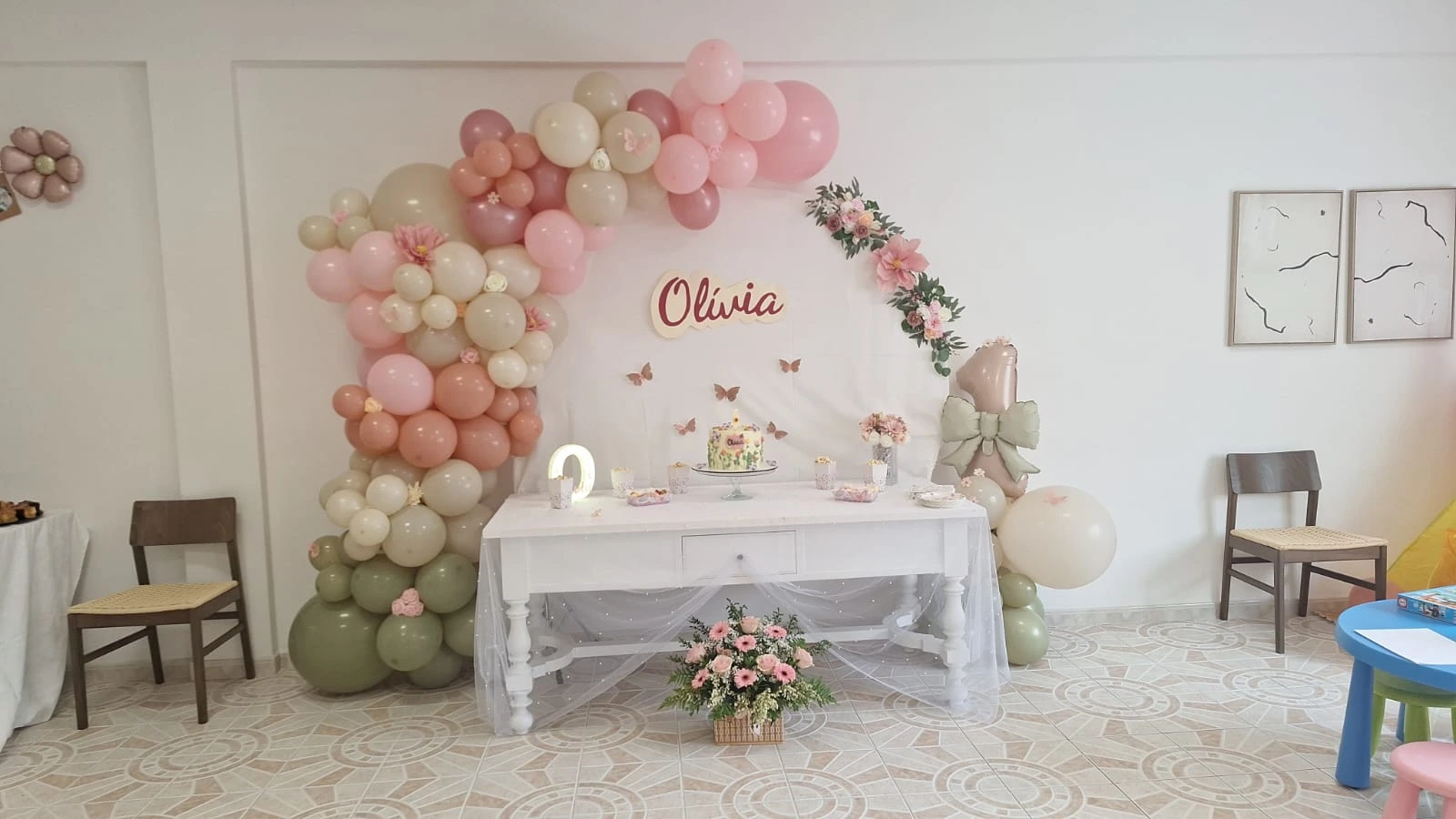 Room decorated with a balloon arch and main table for a celebration.
