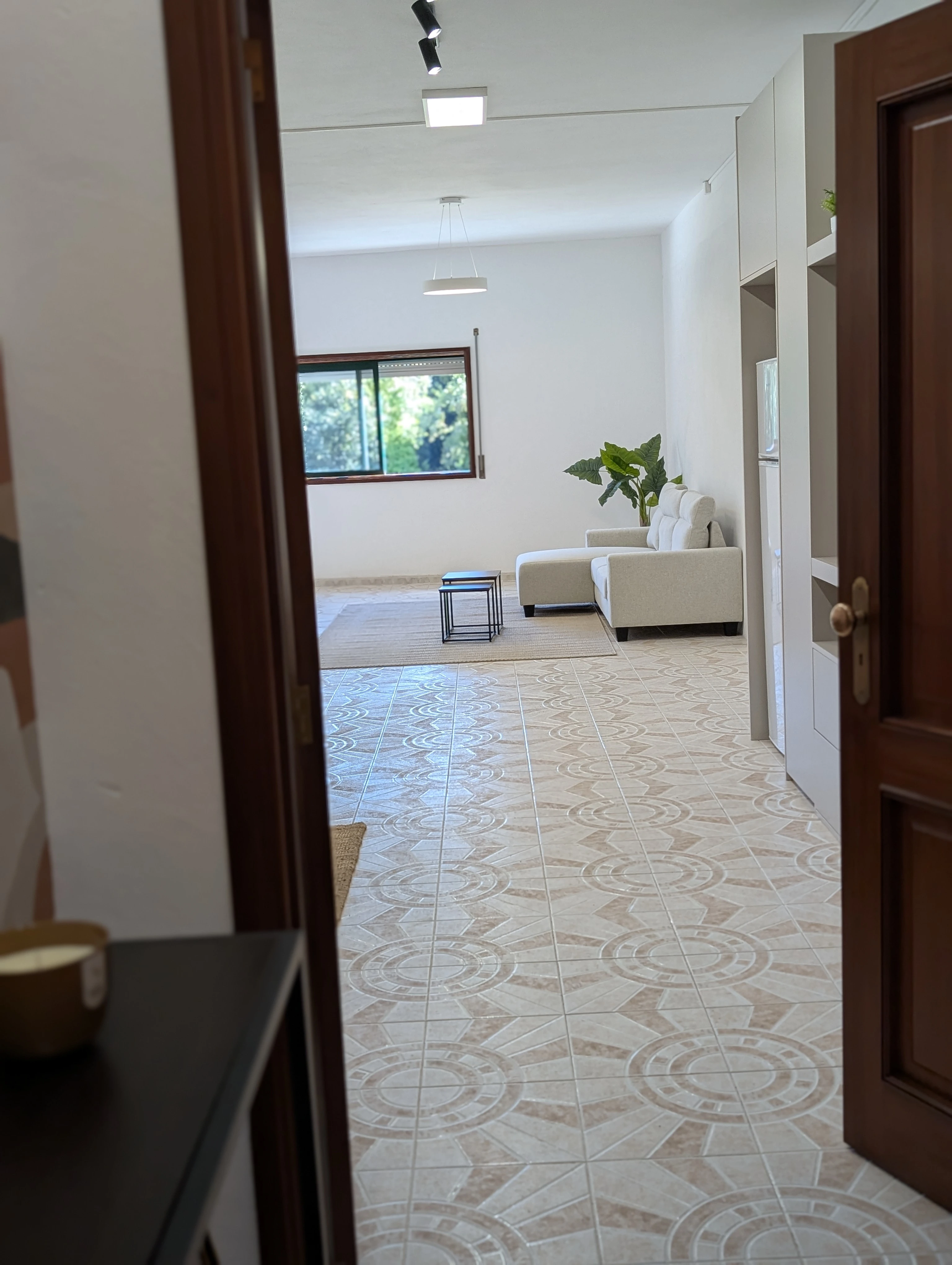 View of the main room from the entrance, with natural light and a lounge area in the back.