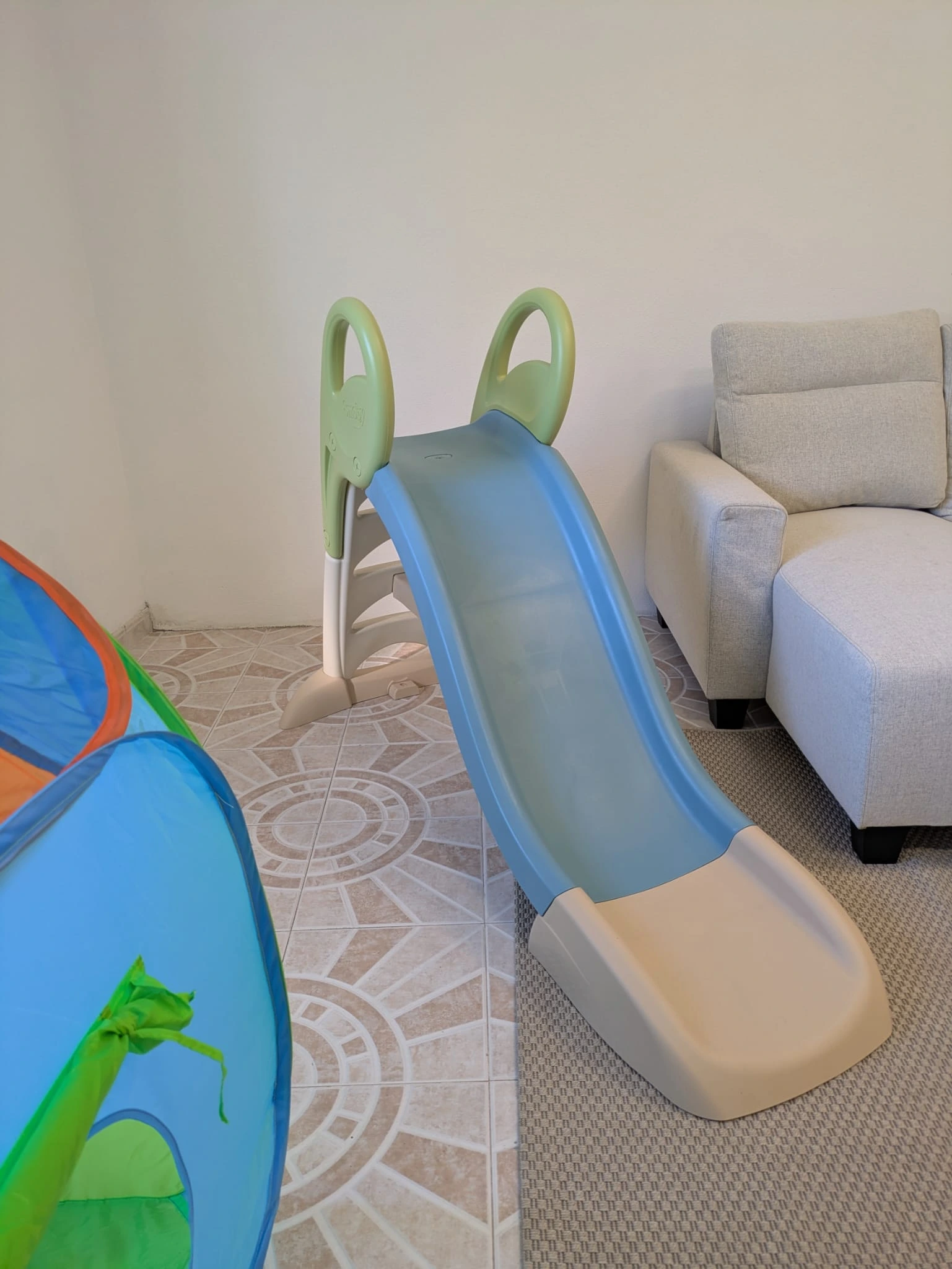 Kids' area with a slide next to the sofa area.